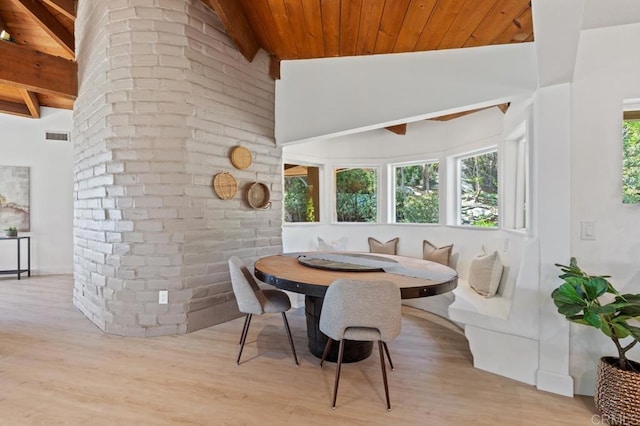 dining room featuring breakfast area, wood ceiling, wood finished floors, and vaulted ceiling with beams