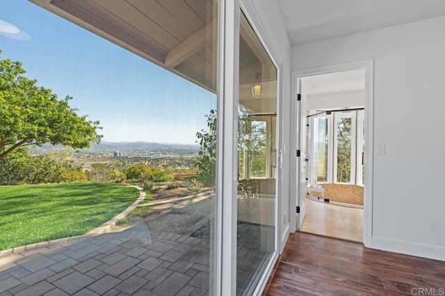 doorway to outside with baseboards and wood finished floors