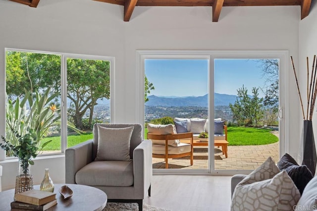 sunroom / solarium with beamed ceiling and a mountain view