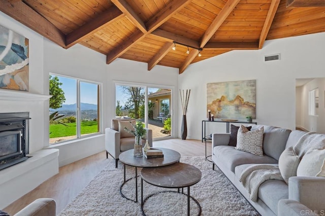 living area featuring visible vents, beamed ceiling, high vaulted ceiling, wood finished floors, and wood ceiling