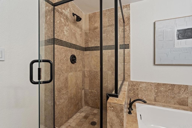 bathroom with a stall shower and a bath