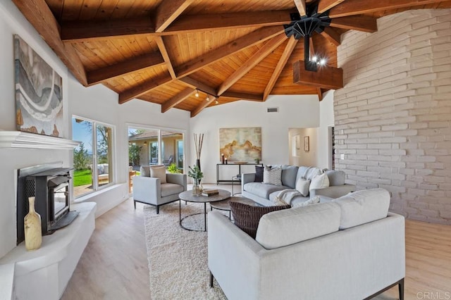 living room with wood finished floors, high vaulted ceiling, beam ceiling, ceiling fan, and wooden ceiling