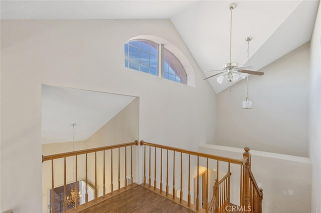 stairway featuring high vaulted ceiling, wood finished floors, and a ceiling fan