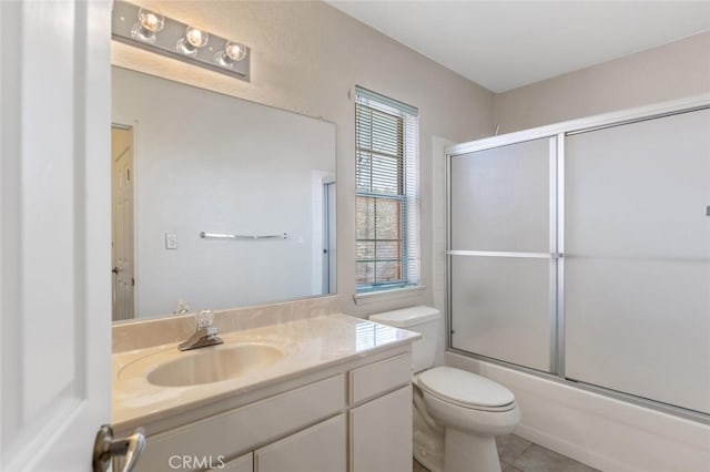 bathroom with bath / shower combo with glass door, tile patterned flooring, vanity, and toilet