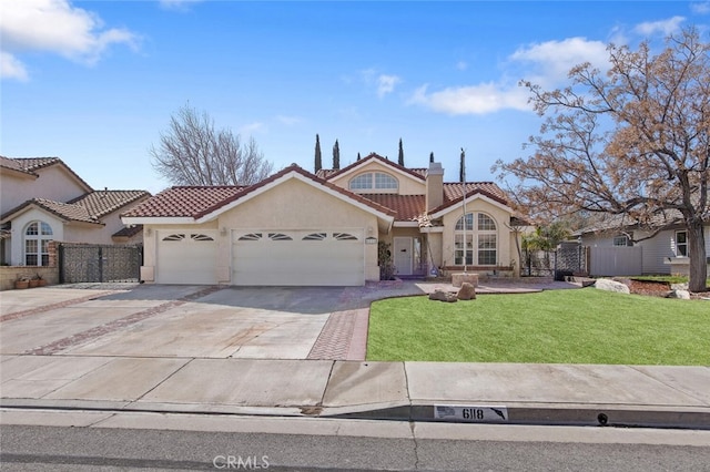 mediterranean / spanish home featuring stucco siding, fence, a garage, a tiled roof, and a front lawn