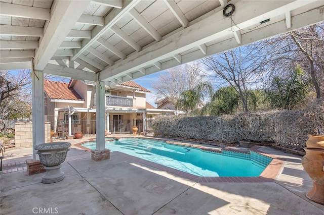 view of swimming pool with a patio area, fence, and a pool with connected hot tub