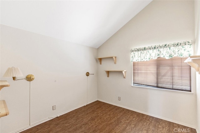 spare room with lofted ceiling, baseboards, and wood finished floors