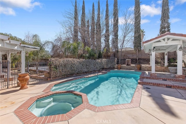 view of swimming pool featuring a patio area, a pool with connected hot tub, and fence