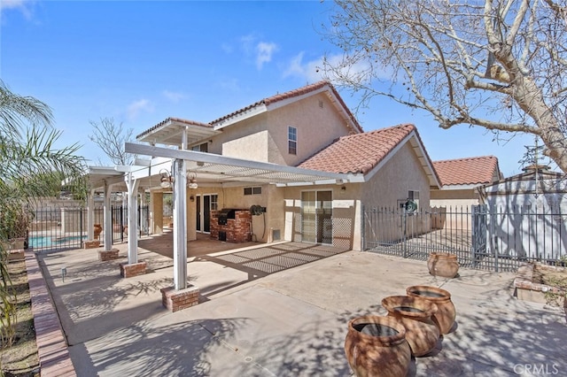 rear view of house with stucco siding, fence, and a patio