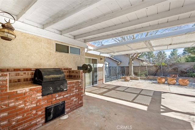 view of patio with a grill, fence, and exterior kitchen