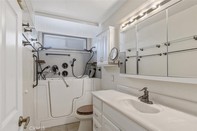 full bathroom with a washtub, vanity, toilet, and tile patterned floors