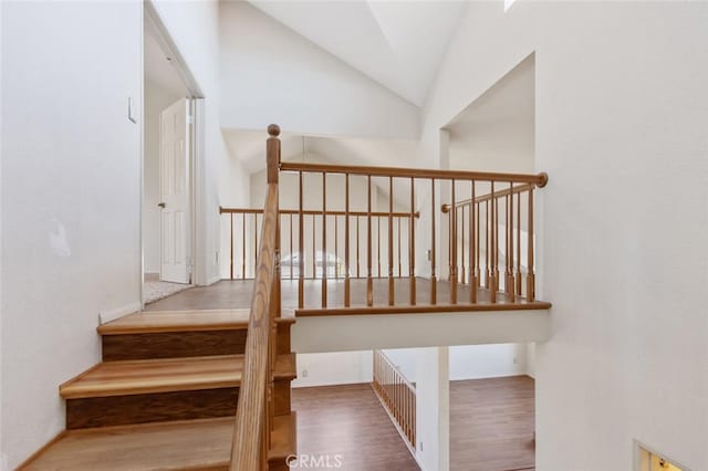 stairway with lofted ceiling and wood finished floors