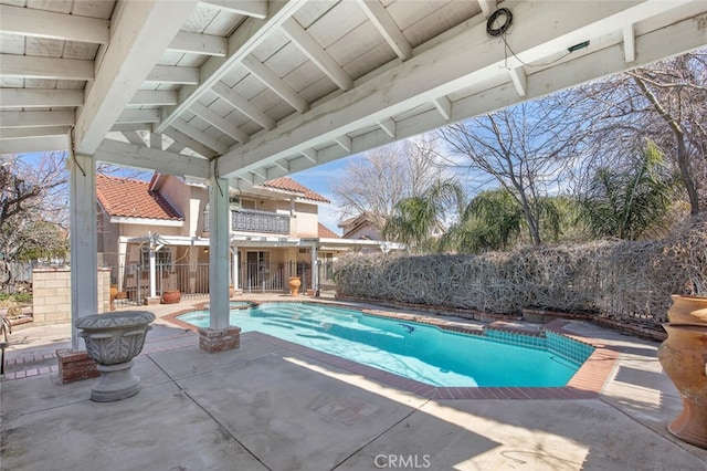 view of swimming pool featuring a patio area, fence, and a pool with connected hot tub