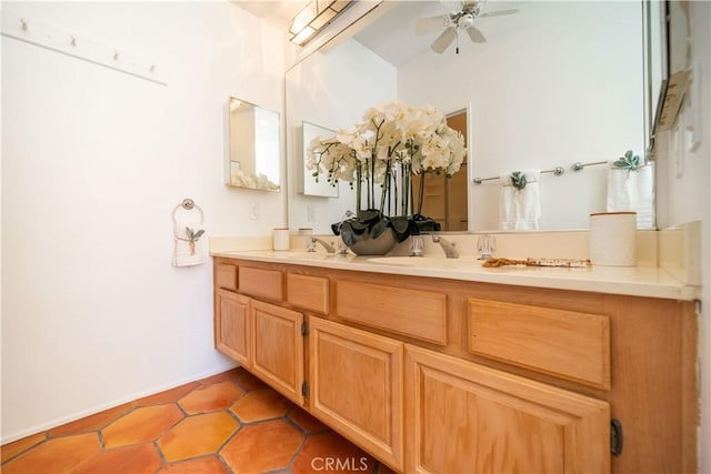 bathroom with double vanity, a ceiling fan, baseboards, and a sink