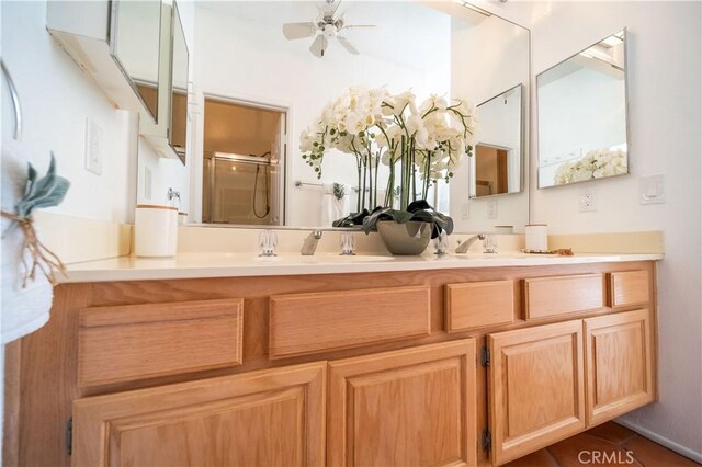 bathroom with double vanity, a ceiling fan, and a stall shower