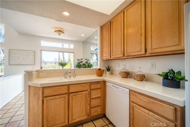 kitchen featuring a sink, recessed lighting, a peninsula, light tile patterned flooring, and white dishwasher