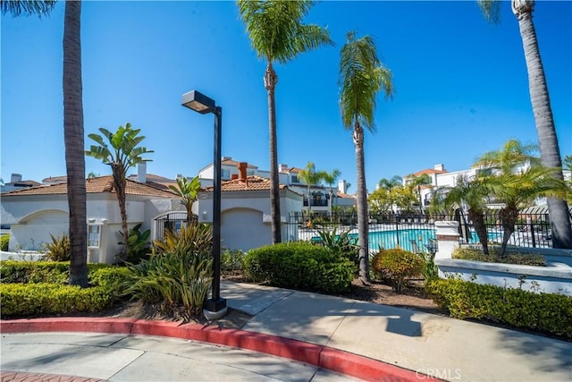 exterior space with a community pool and fence