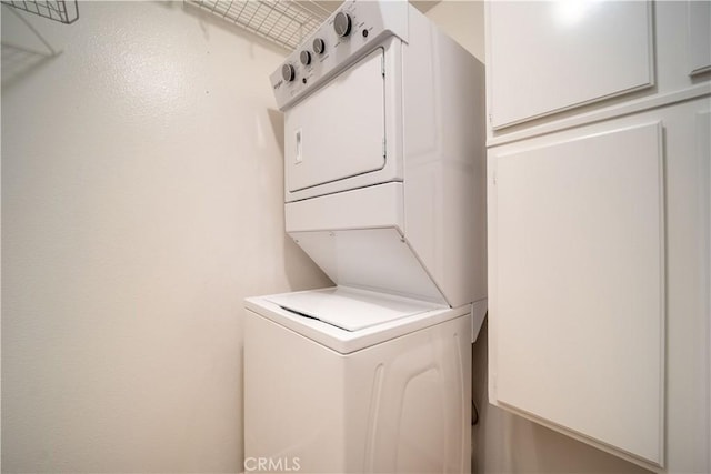 washroom featuring stacked washer and clothes dryer