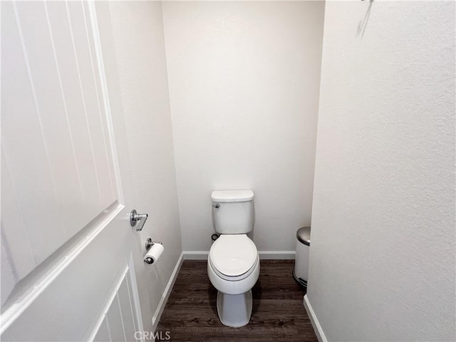 bathroom with wood finished floors, toilet, and baseboards