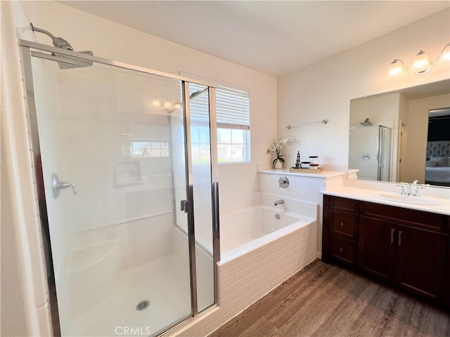 ensuite bathroom featuring ensuite bath, wood finished floors, vanity, a shower stall, and a bath