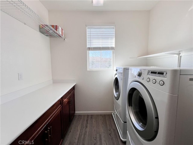 washroom with baseboards, wood finished floors, and washing machine and clothes dryer