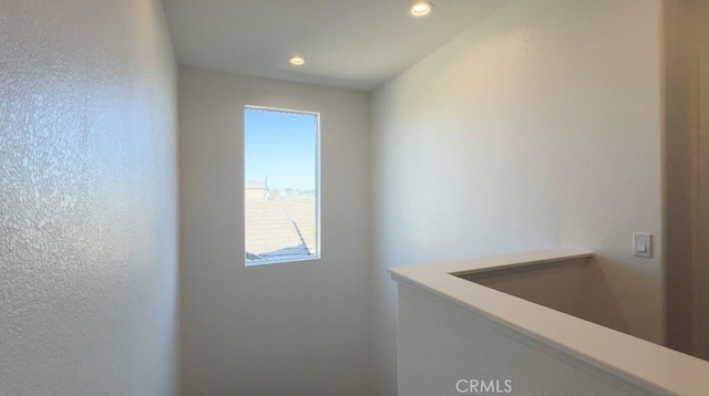 interior space featuring recessed lighting and a textured wall