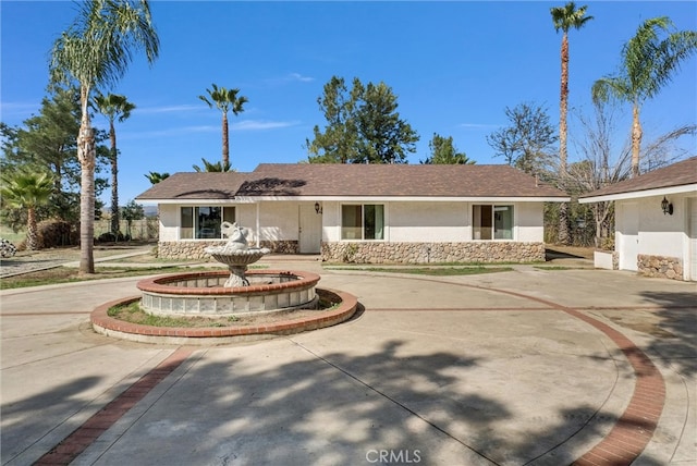 ranch-style house with driveway and stucco siding