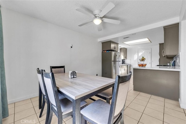 dining room with a ceiling fan, visible vents, a textured ceiling, and light tile patterned floors