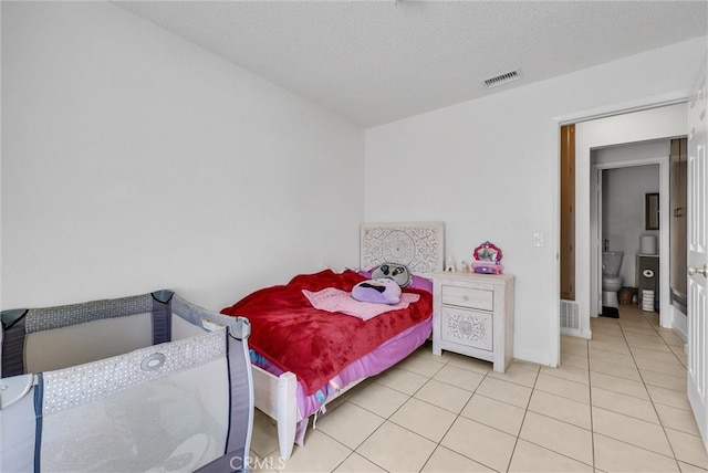 bedroom featuring visible vents, a textured ceiling, and light tile patterned flooring