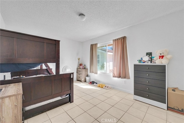 bedroom featuring light tile patterned flooring, a textured ceiling, and baseboards