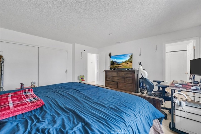 bedroom with a textured ceiling and a closet