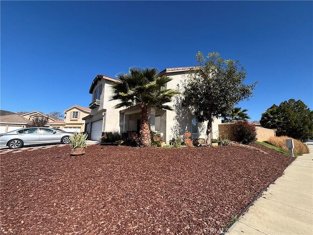 exterior space featuring stucco siding, concrete driveway, and a garage