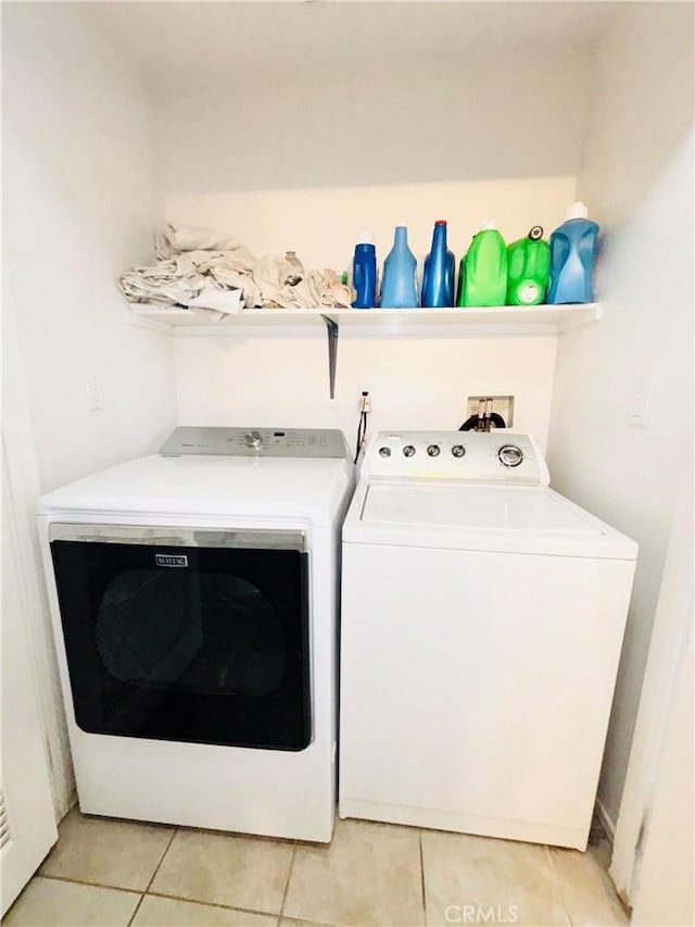 laundry area featuring washing machine and clothes dryer, laundry area, and light tile patterned floors