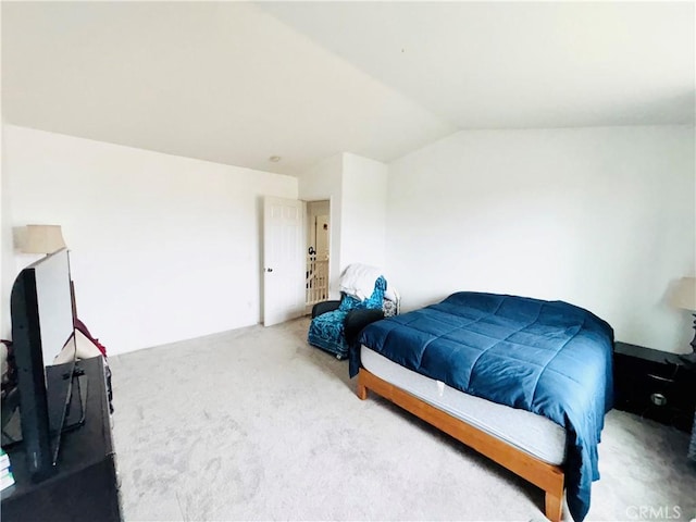 bedroom featuring lofted ceiling and carpet