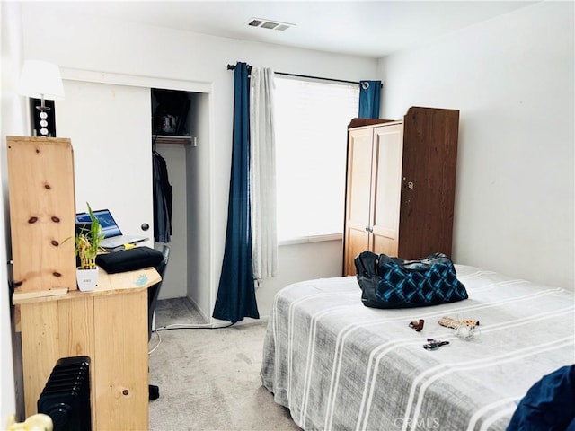 bedroom featuring visible vents, light carpet, radiator, and a closet