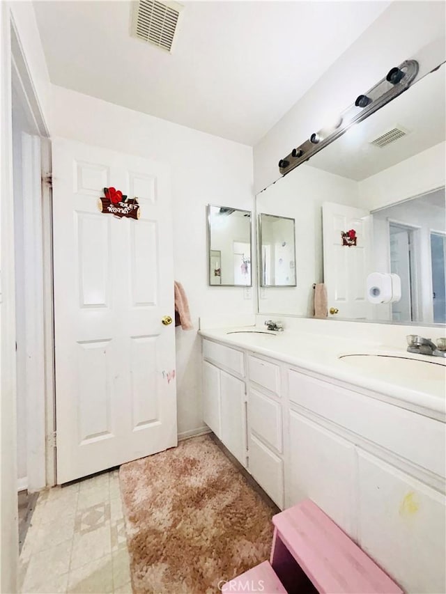 full bathroom with double vanity, visible vents, and a sink