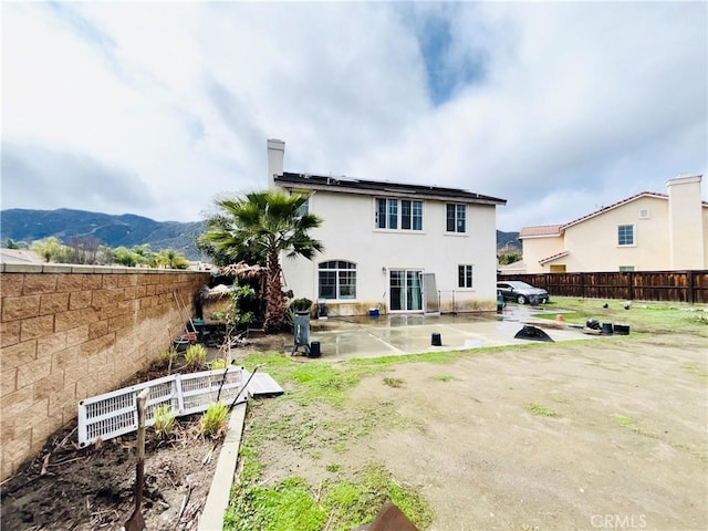 back of house featuring stucco siding, a patio, a fenced backyard, and a mountain view