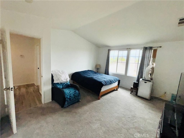 carpeted bedroom with lofted ceiling