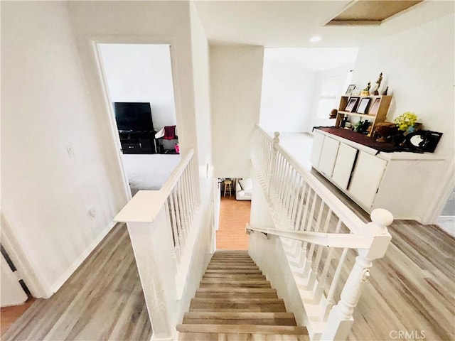 stairway featuring baseboards and wood finished floors