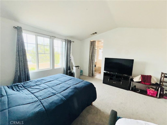 bedroom with visible vents, lofted ceiling, and carpet floors