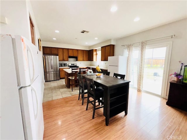 kitchen with light countertops, light wood finished floors, visible vents, and appliances with stainless steel finishes