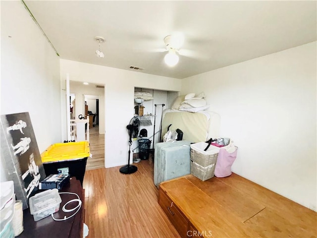 interior space with a ceiling fan, wood finished floors, and visible vents