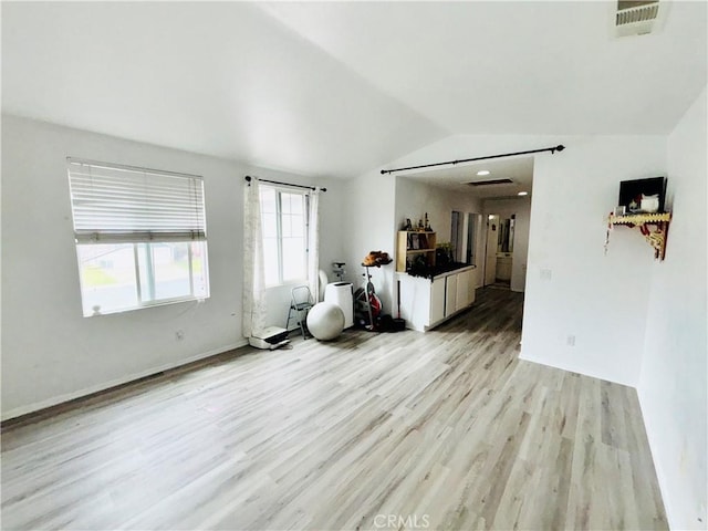 unfurnished living room featuring vaulted ceiling, light wood-style floors, and visible vents