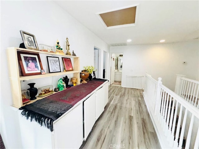 corridor with light wood-type flooring, an upstairs landing, visible vents, recessed lighting, and attic access