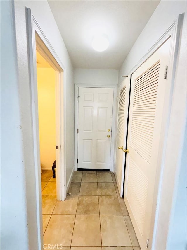 hall with light tile patterned floors and baseboards