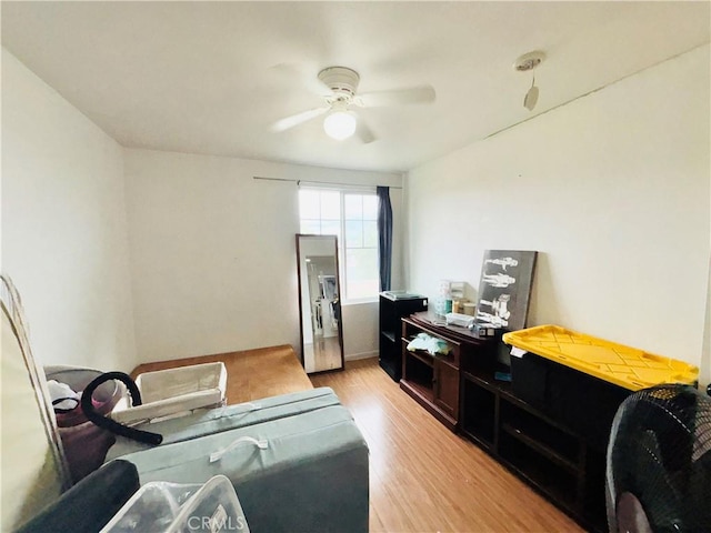 living area with light wood-style floors and ceiling fan