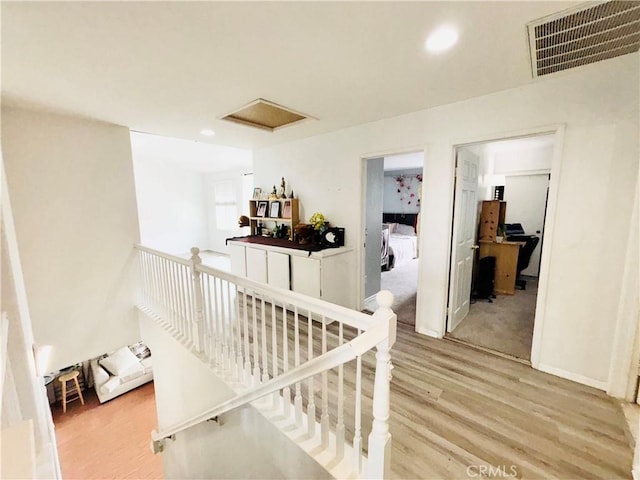 staircase with attic access, recessed lighting, wood finished floors, and visible vents