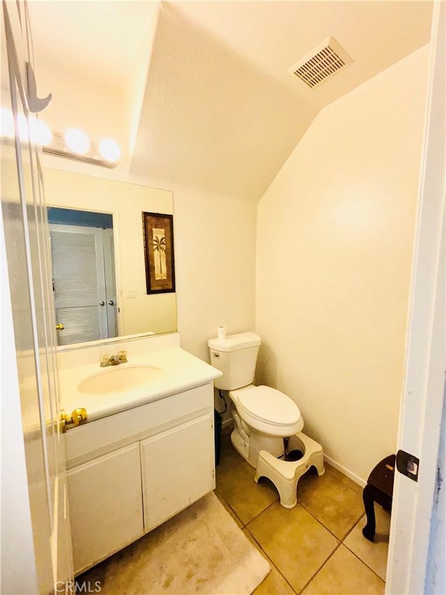 bathroom featuring vanity, visible vents, vaulted ceiling, tile patterned floors, and toilet