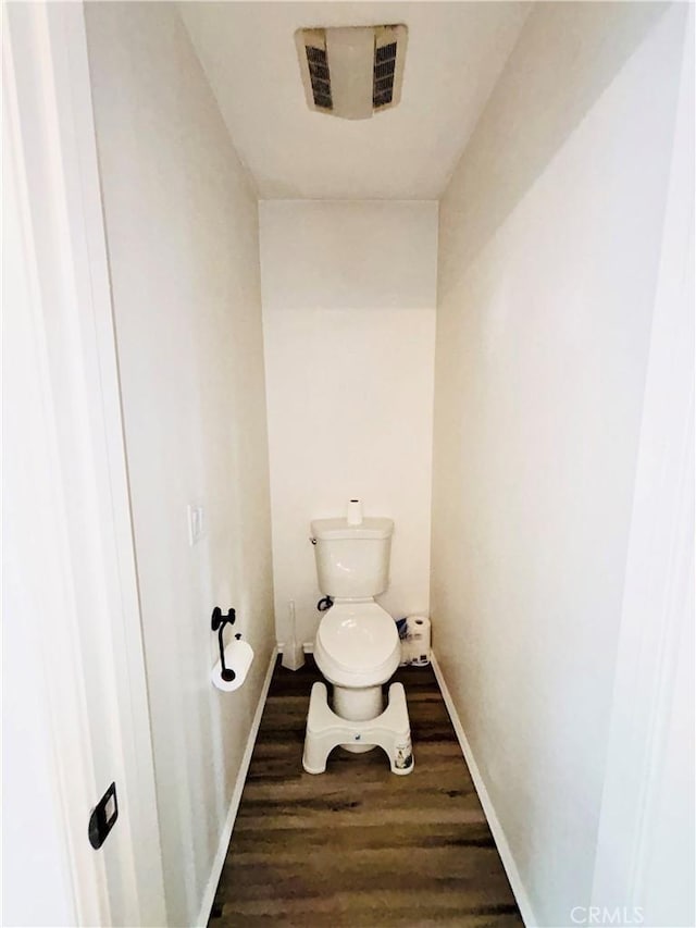 bathroom with toilet, wood finished floors, visible vents, and baseboards