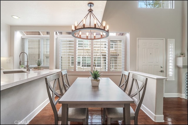 dining space featuring a notable chandelier, baseboards, and dark wood-style flooring